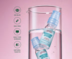 Two small bottles of Lubricating Eye Drops Moisture Oyster with light blue caps and labels, partially submerged inside a clear glass beaker on a pink background, with five green feature icons and text on the left.